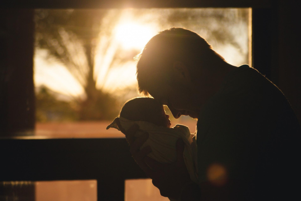 Man holding a newborn baby.