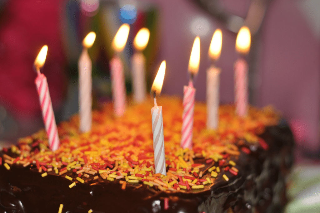 Chocolate birthday cake with sprinkles and eight candles.