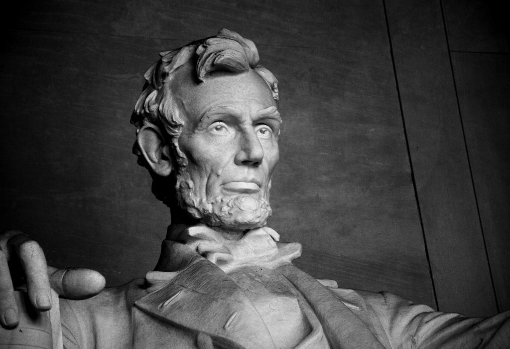 Black and white image of statue of Abraham Lincoln wearing a suit.